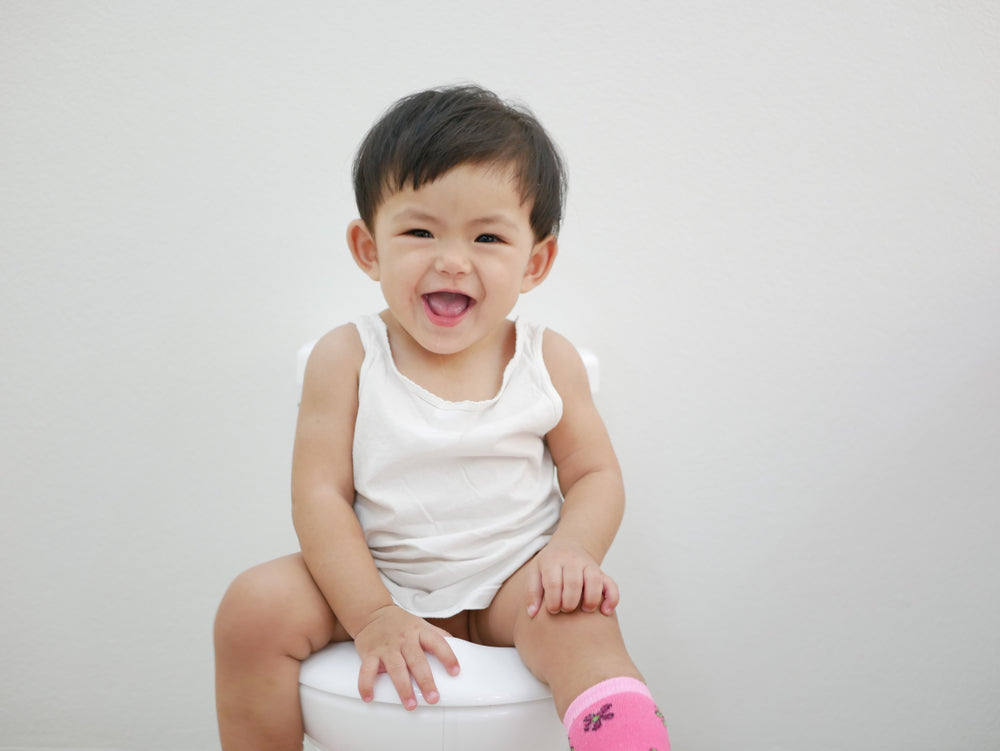 baby sit on a baby-size toilet for a toilet training